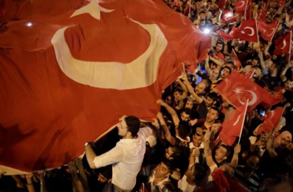 People hold Turkish flags in Taksim square in Istanbul on July 16, 2016 during a demonstration in support to Turkish president. 
