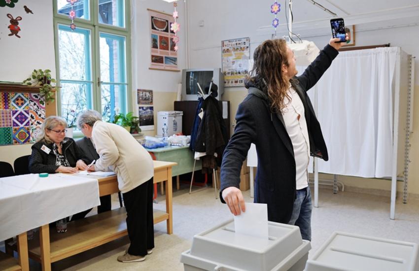 Man taking a selfie at a voting booth