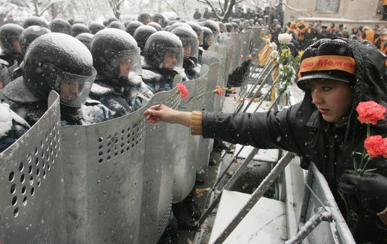 Woman handing rose to soldiers