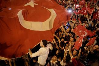 Des sympathisants agitent des drapeaux turcs sur la place Taksim à Istanbul 
le 16 juillet 2016, lors d’une manifestation de soutien au Président turc. 
©AFP/Yasin Akgul

