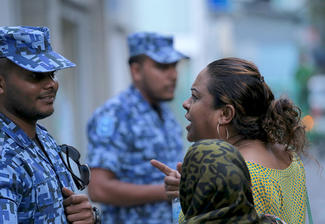 Protesters argue with security forces outside parliament in Male.
