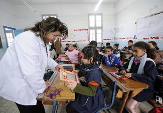 A Tunisian teacher works with her students on March 8, 2011 in Tunis