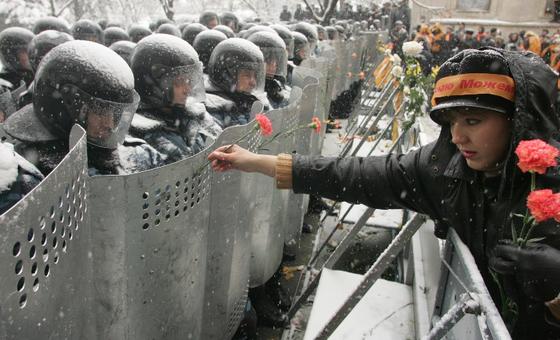 Woman handing rose to soldiers